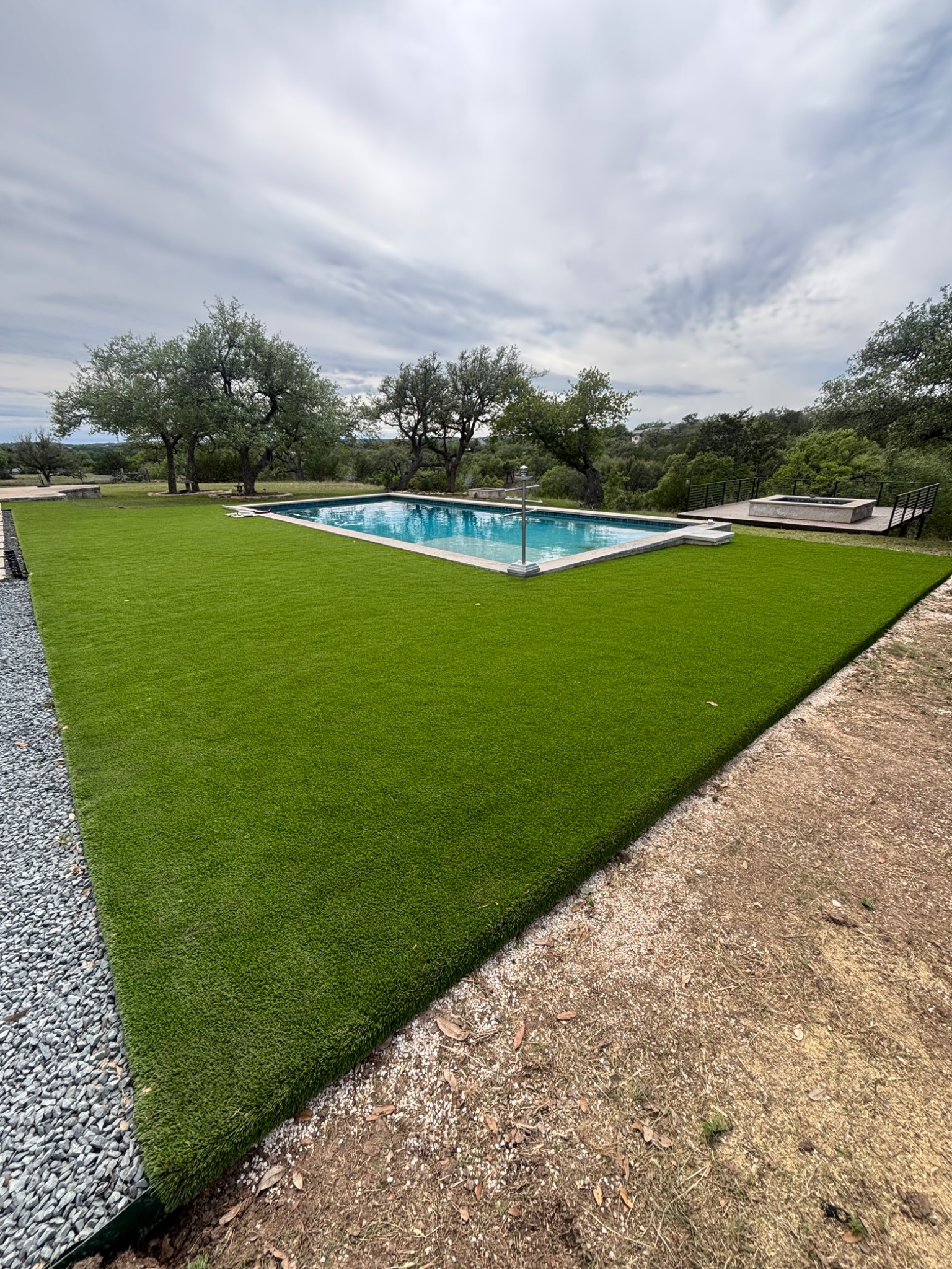 Large artificial turf installation surrounding a pool in the Texas Hill Country
